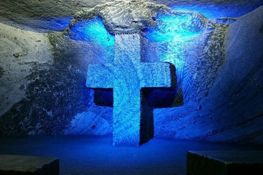 Una cueva de hielo con una gran formación de hielo cruzada, iluminada con luz azul. 5