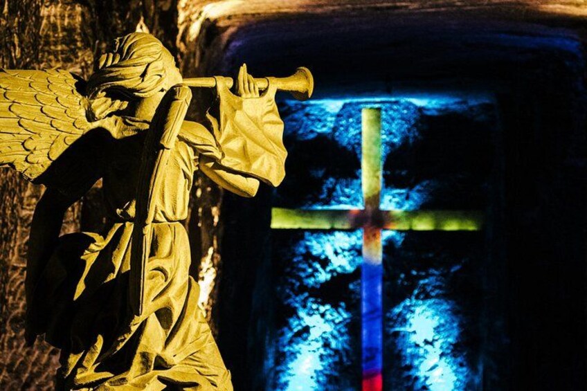 A statue of an angel with wings, a cross, and a stained glass window. 3