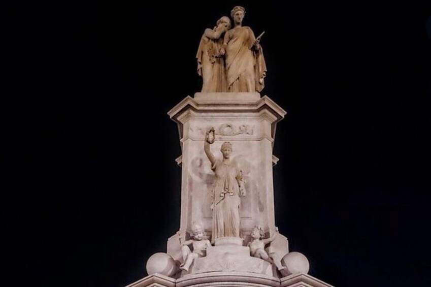 A marble statue of two figures on a pedestal. 3