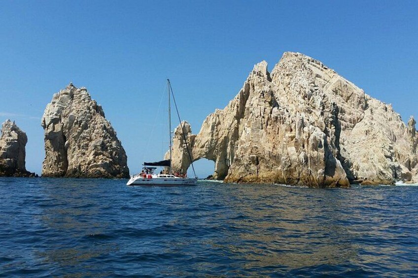 A boat sailing near rocky formations in the sea. 1