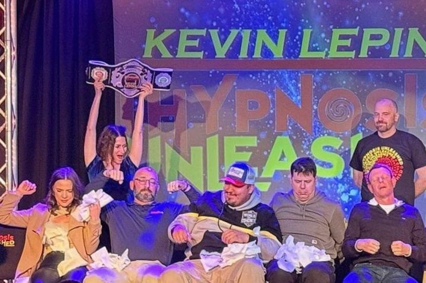 Un gruppo di persone su un palco con uno striscione che riporta 'KEVIN LERIN' e 'IPNOSI'. 4