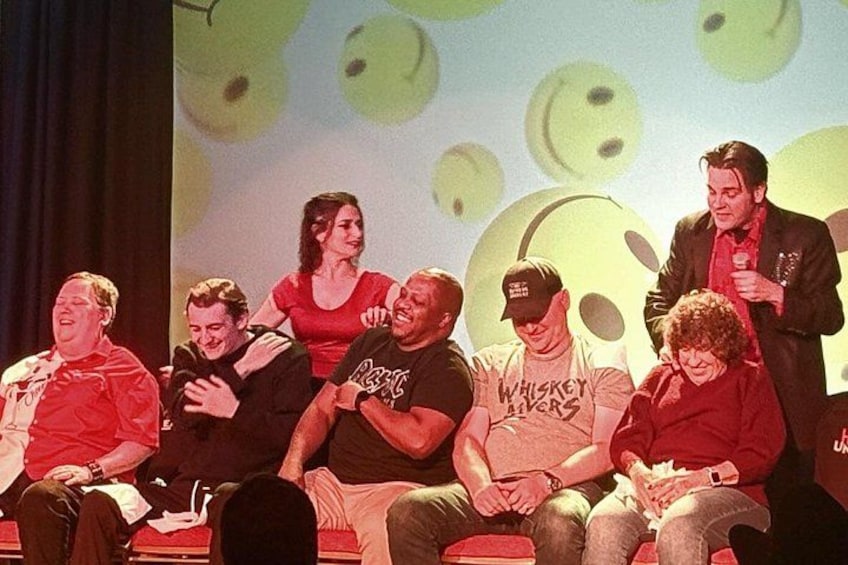 Un gruppo di persone su un palco con uno sfondo a motivi circolari. 5
