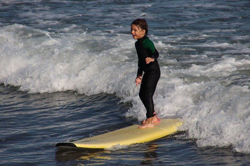 A person surfing on a yellow surfboard in the ocean. 2