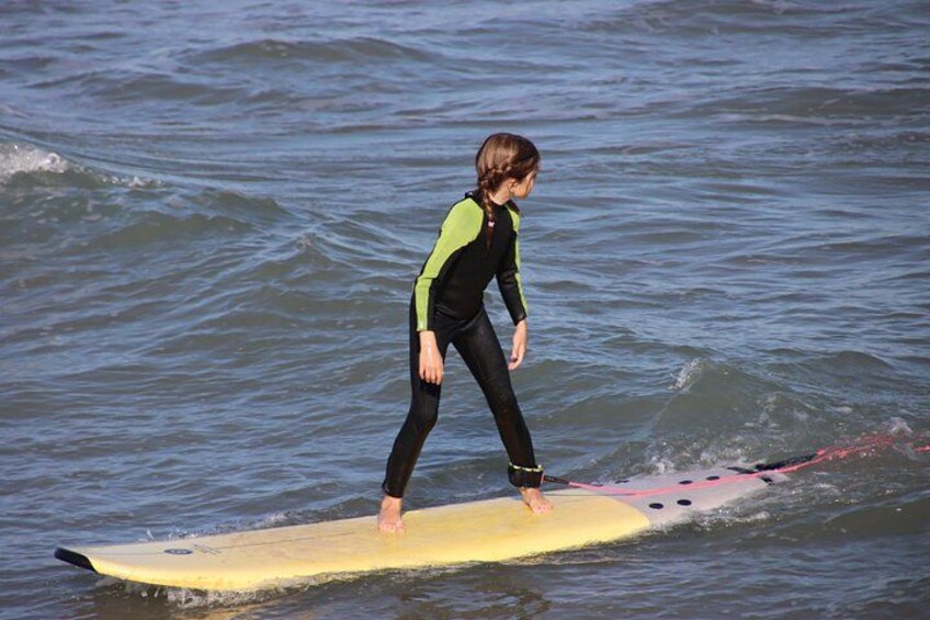 A person surfing on a yellow surfboard in the ocean. 4