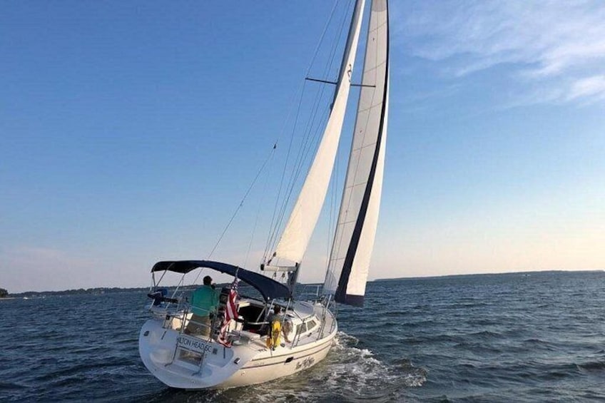 Ein Segelboot mit weißen Segeln auf dem Wasser. 2