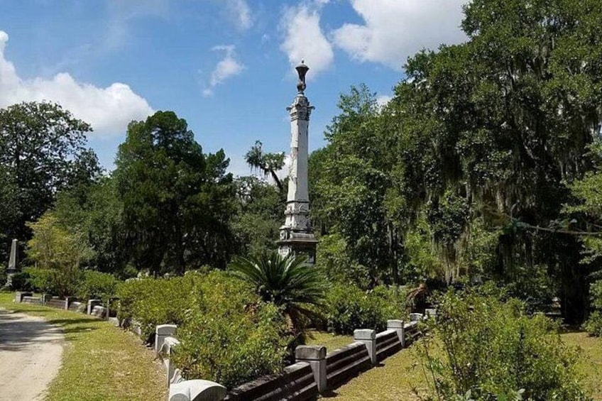 Ett vitt monument i en park med frodig grönska och träd. 3