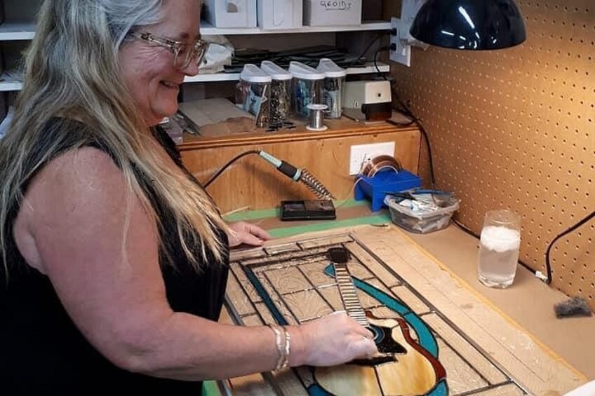 Eine Person spielt auf einer Holzgitarre. 2