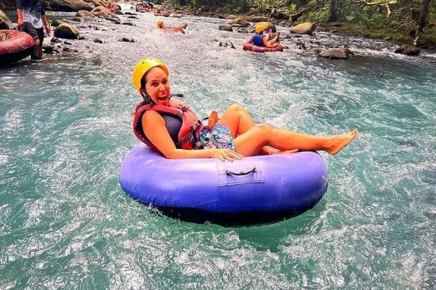 Une personne flottant sur une bouée gonflable bleue dans une rivière. 1