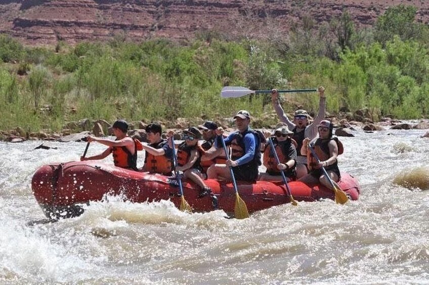 A group of people in a red raft navigating a river. 4