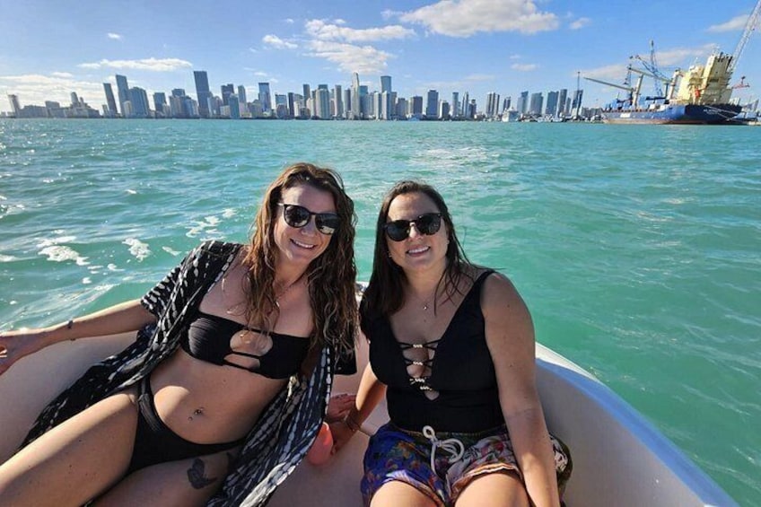 Two people on a boat with a city skyline in the background. 4