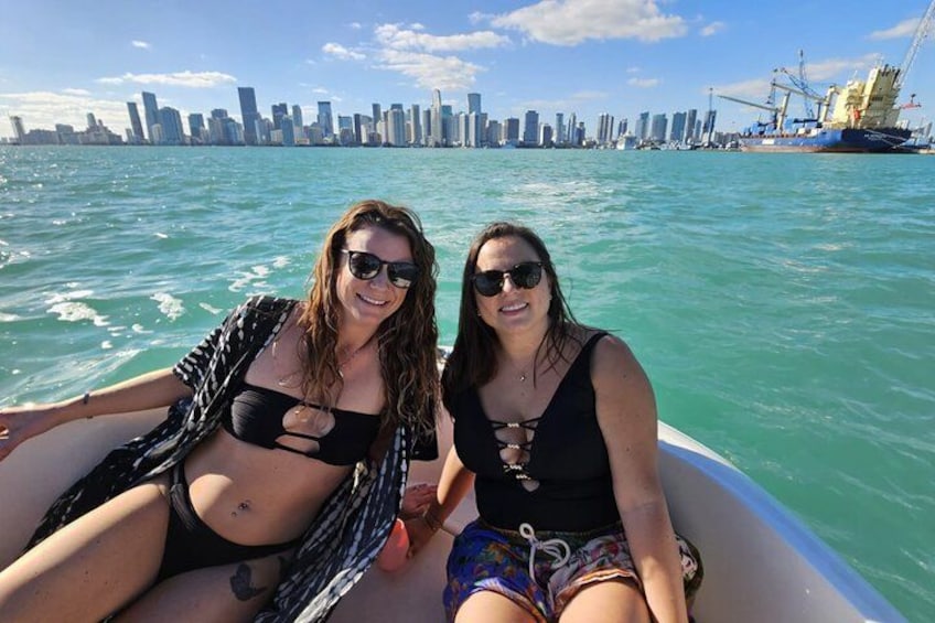 Deux personnes se trouvent sur un bateau, avec la silhouette d’une ville en arrière-plan. 4