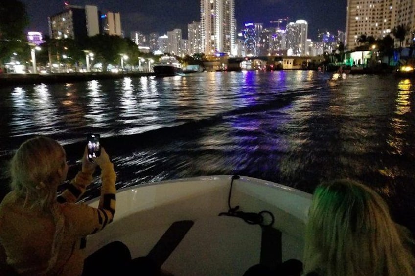 Un paseo en barco de noche con el horizonte de la ciudad al fondo. 2