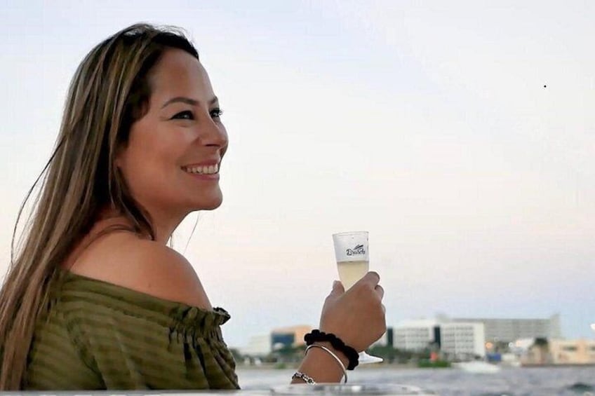 A person holding a drink with a cityscape in the background. 5