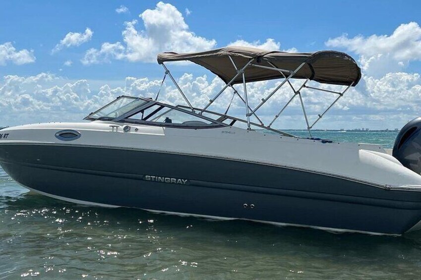 A Stingray boat with a canopy, floating on calm water. 5