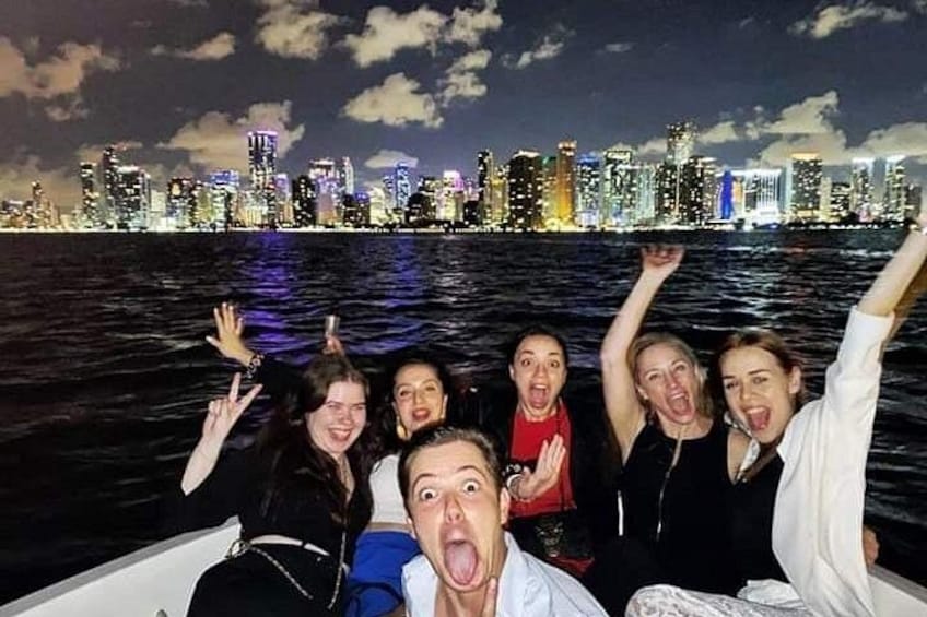 Un grupo de personas en un barco, con el horizonte de una ciudad al fondo. 3