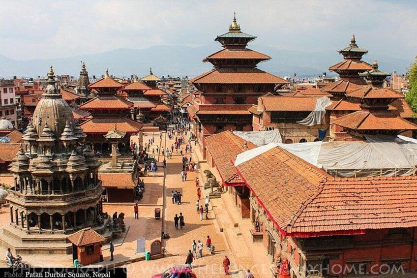 A historic square with traditional buildings and a prominent stupa. 5