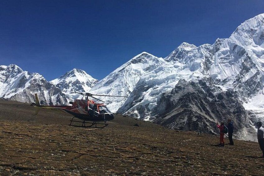 Un helicóptero en un día despejado, un paisaje montañoso y una persona al frente. 3