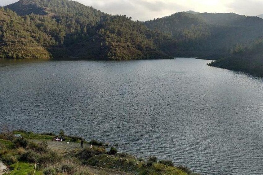 A calm lake surrounded by forested hills. 4