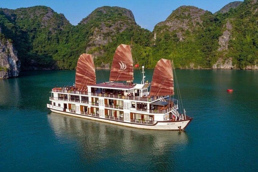 Ein großes Flussdampfschiff mit mehreren Decks und Segeln, das auf einem ruhigen Fluss vor den grünen Hügeln dahingleitet. 4