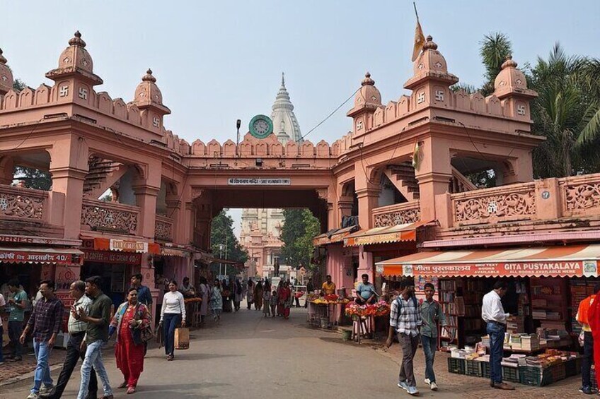 A bustling market area with a prominent pink archway and various stalls. 2