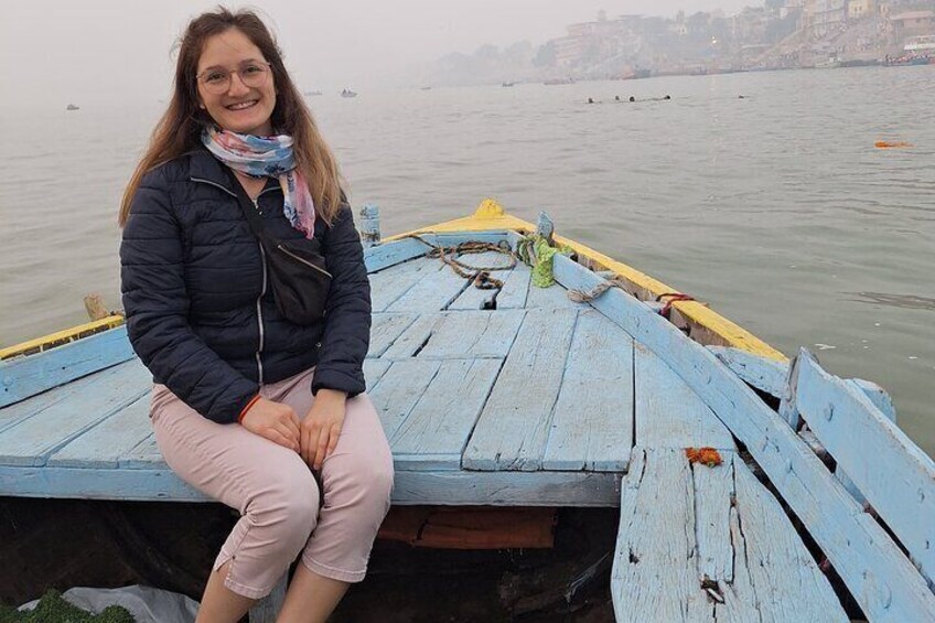 A person sitting on a wooden boat docked by a river. 4