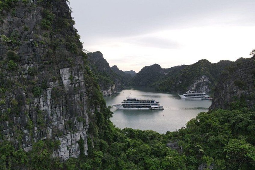 A river with boats, surrounded by steep cliffs and dense greenery. 2