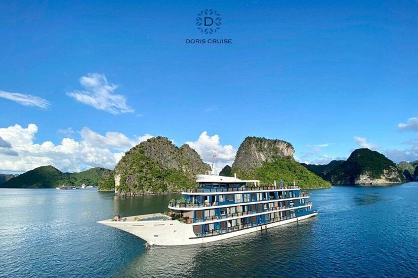 A large cruise ship with multiple decks, surrounded by calm waters and green islands. 3