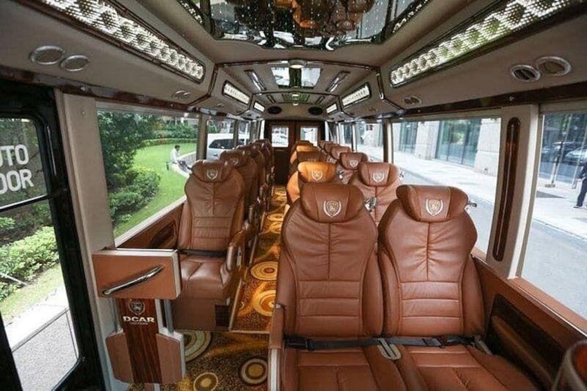 A luxury train interior with leather seats, a patterned floor, and large windows. 3