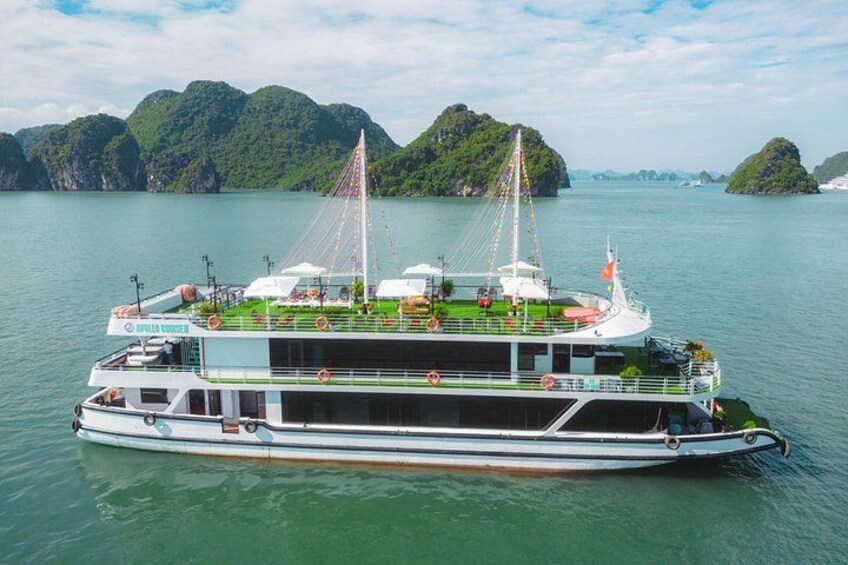 A large boat with a deck area, surrounded by calm water and green islands in the background. 5