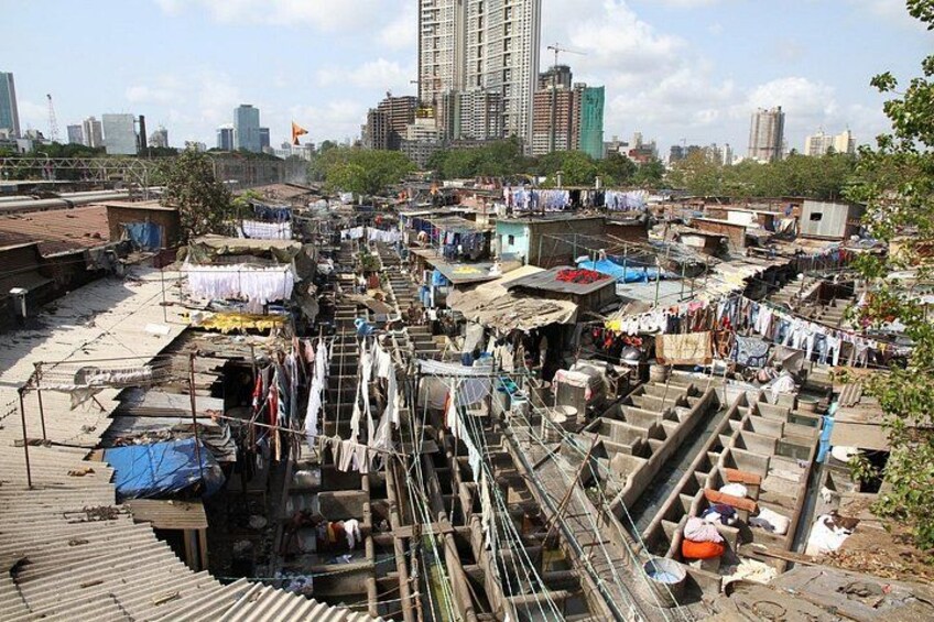 A densely populated urban area with makeshift housing and a large water channel. 1