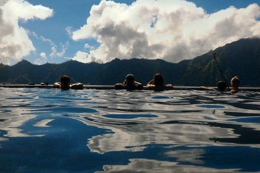 People swimming in a body of water with mountains in the background. 4