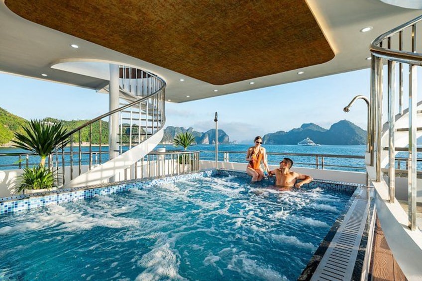 A hot tub on a cruise ship deck with a view of the sea and mountains. 4