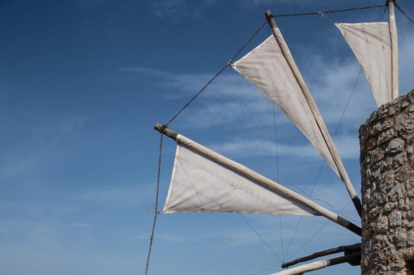 A sailboat with white sails against a clear blue sky. 4