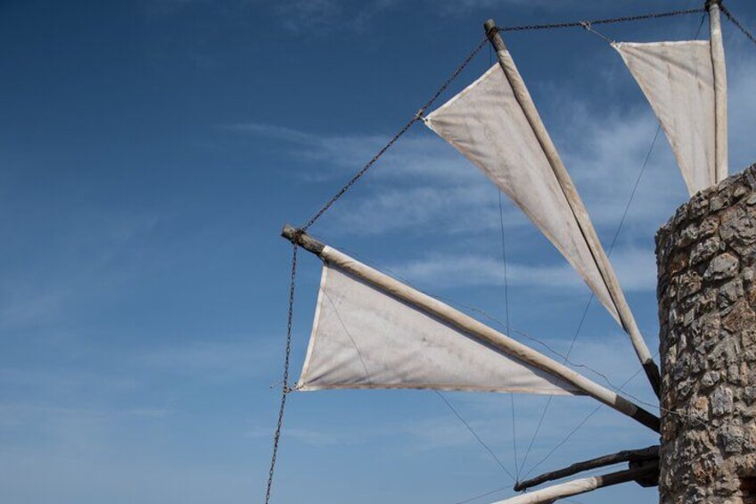 A sailboat with white sails against a clear blue sky. 4
