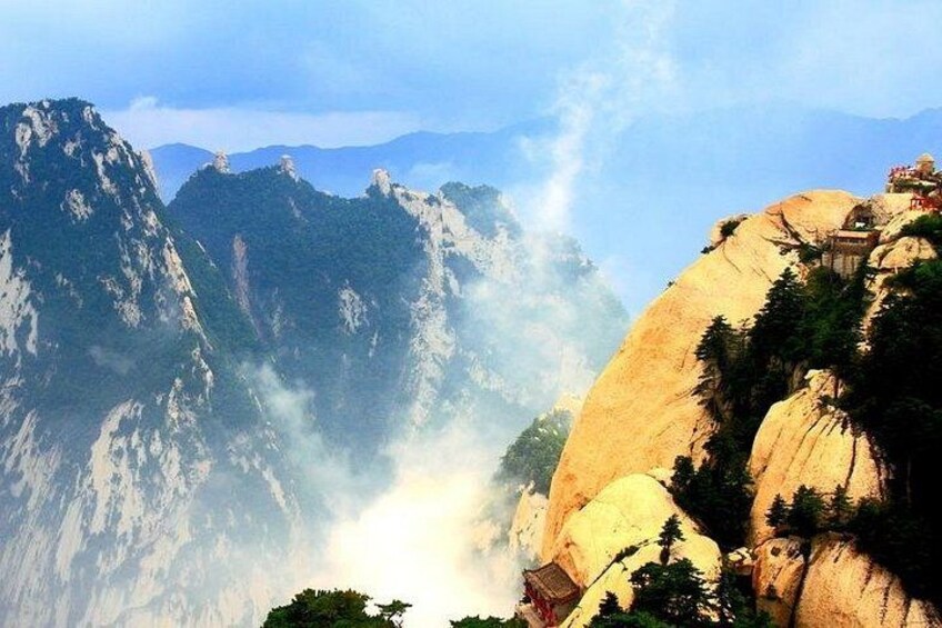 A mountainous landscape with a waterfall, rocky cliffs, and a temple on top. 4