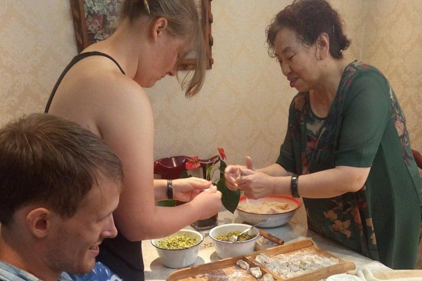 A person preparing food, with bowls and a cutting board on the table. 3