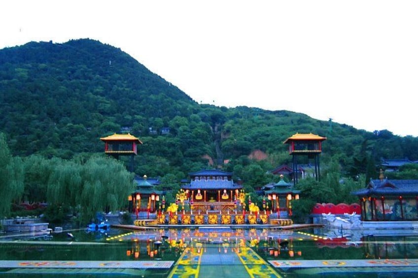 Een traditioneel Chinees paviljoen met een weerspiegeling in het water, omringd door weelderige begroeiing en heuvels. 5