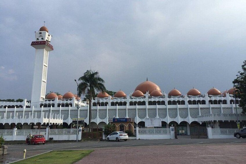 A mosque with a tall minaret and multiple domes. 2