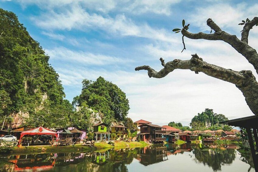 A calm lake with reflections, surrounded by lush greenery and traditional houses. 1