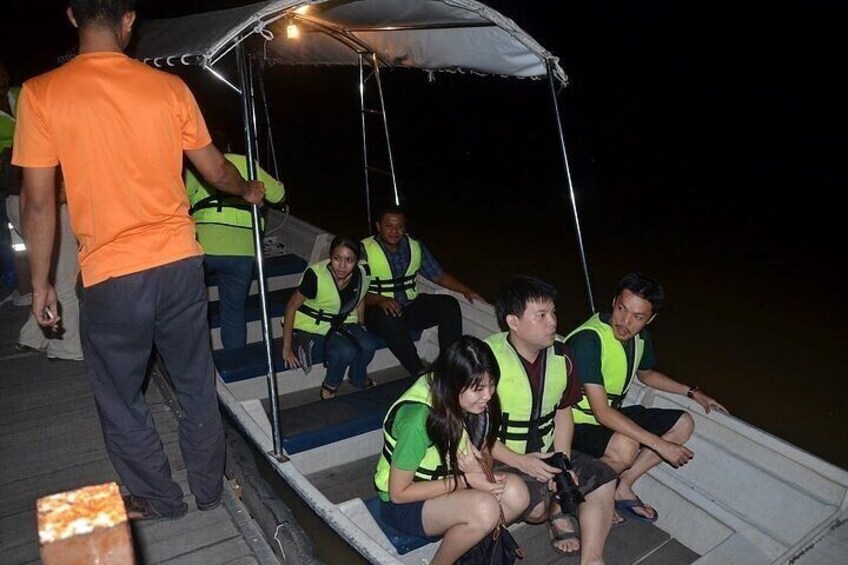 People sitting on a boat with a canopy, wearing life jackets. 3