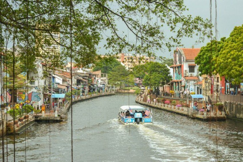 A narrow waterway with a boat, lined with colorful buildings and trees. 4
