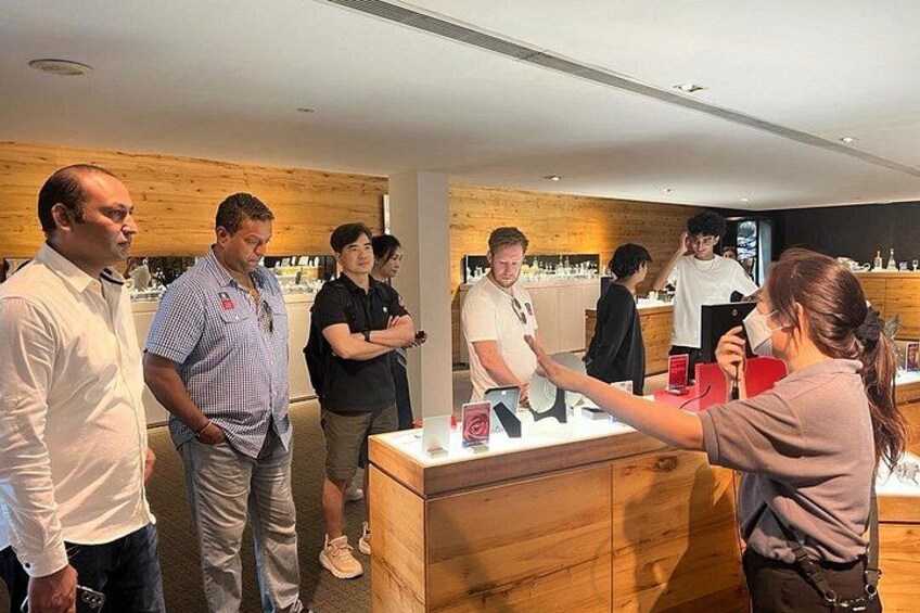A group of people in a modern interior space with wooden accents and a counter. 4