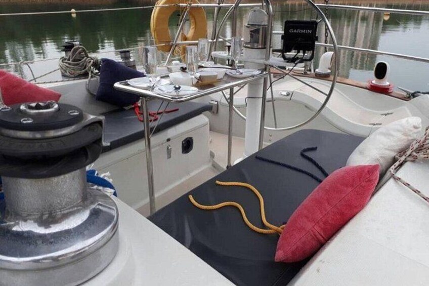 Le pont d’un bateau, avec un volant, un appareil Garmin, un gilet de sauvetage et un coussin. 4