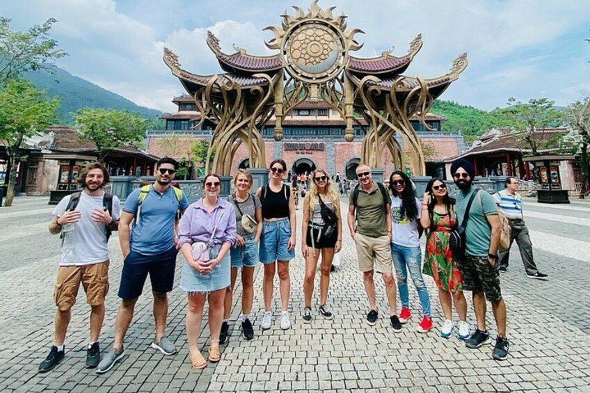 A group of people standing in front of a traditional building with ornate architecture. 4
