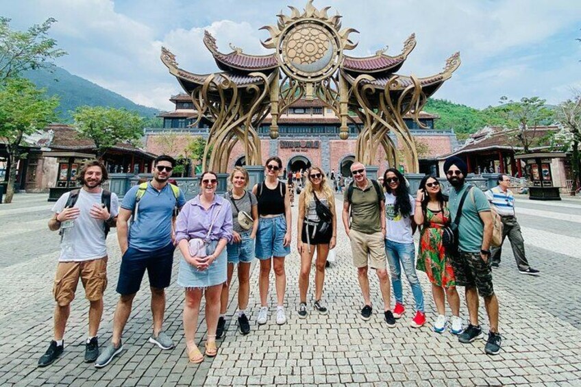 Un grupo de personas frente a un edificio tradicional con arquitectura ornamentada. 4