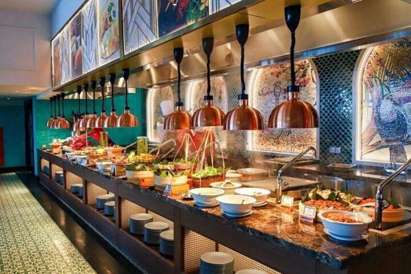 A buffet with various dishes, hanging copper lamps, and a tiled backsplash. 4