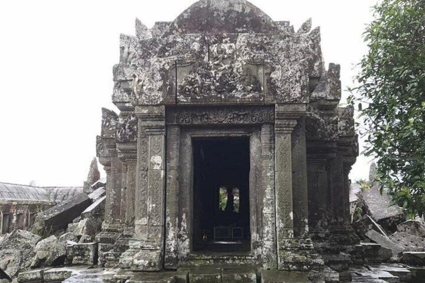 Ingang van een oud tempel met gedetailleerde gravures en een donkere deuropening. 2