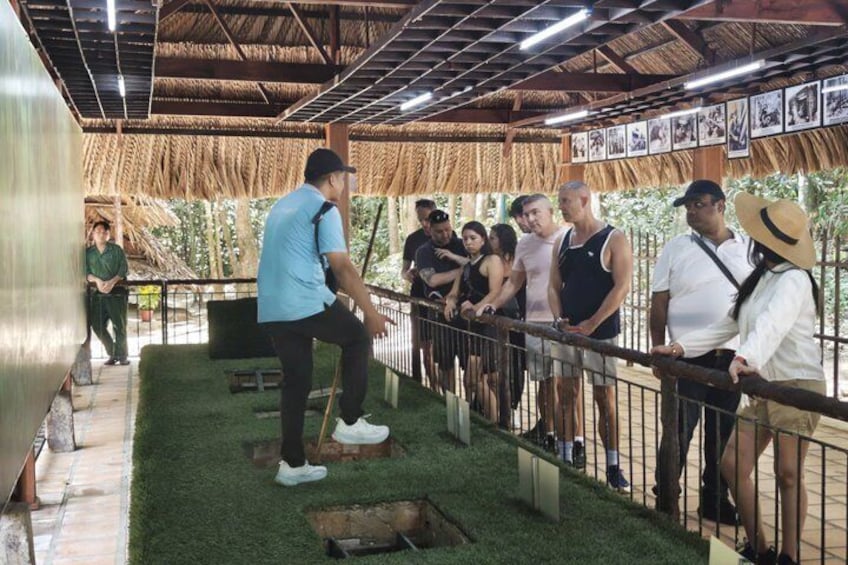 A group of people observing a demonstration with a man in a blue shirt and a woman in a straw hat. 1