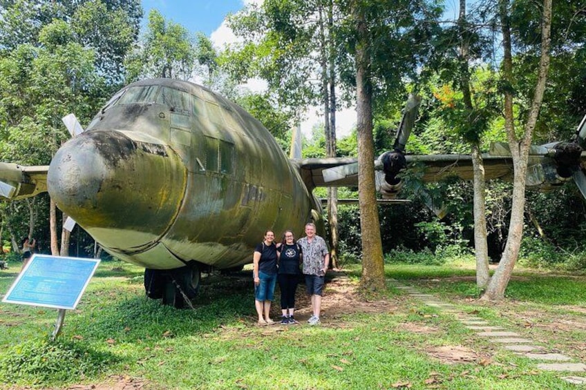 A large, weathered aircraft on display in a grassy area with trees in the background. 4