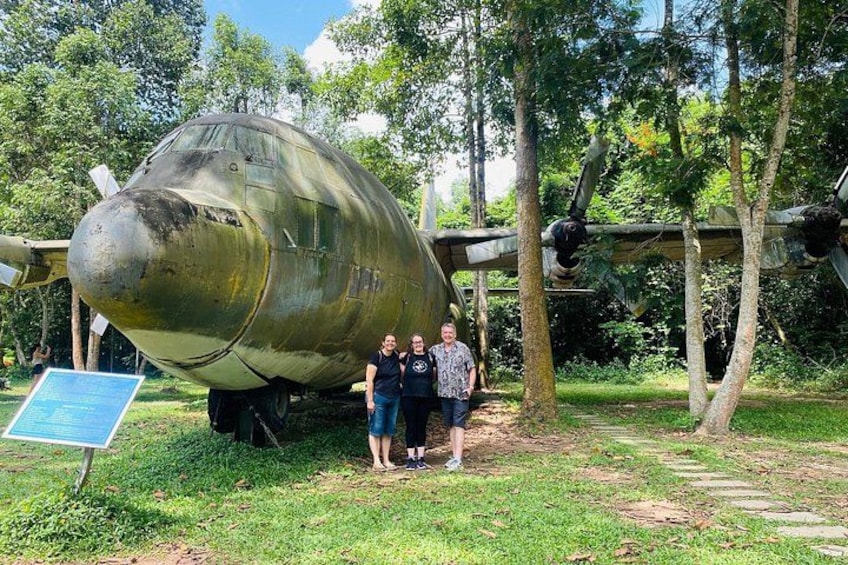 A large, vintage aircraft on display in a grassy area with trees in the background. 4